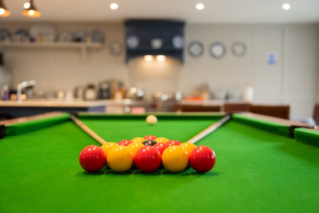 Pool table beside a shared kitchen at Lavender Manor